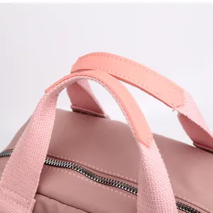 Detailed view of pink casual backpack handle and zipper, durable and stylish design.