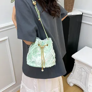 Trendy diamond quilted denim bucket bag with chain strap and pearl drawstring for women.