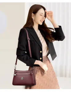 Detailed view of women wine red shoulder bag, elegant vintage design with multi pockets.