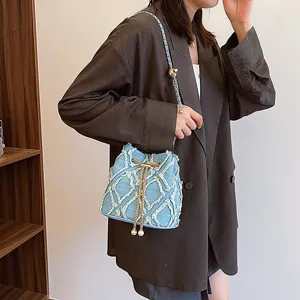 Stylish denim bucket bag featuring quilted frayed embroidery, chain strap and pearl accents.