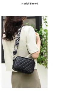 Detail view of black quilted leather crossbody bag with chic black and white pattern strap.
