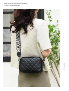 Black quilted leather crossbody bag with wide geometric pattern strap, elegant detail view.