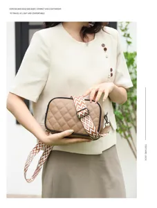 Detailed shot of genuine leather quilted crossbody bag with stylish patterned wide strap.