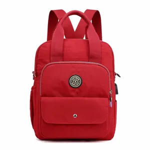 Mochila de nylon roja para mujer con asas superiores, múltiples bolsillos y puerto USB.