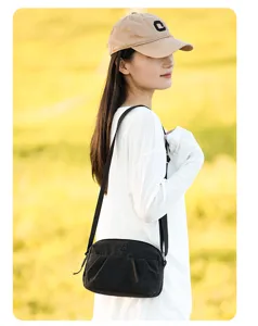 Κοντινή λεπτομερής λήψη της μαύρης casual τσάντας ώμου με κομψές πτυχώσεις και λουράκι.