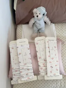 Vue détaillée de jambières douces à motif d'ours et pois, chaussettes cosy en chambre.