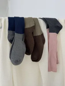 Vue détaillée de chaussettes slouch pour femmes avec blocs de couleur et tricot côtelé.
