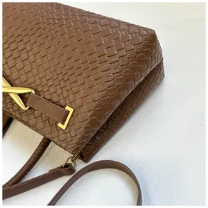 Close-up detail view of the brown woven leather shoulder bag with exquisite metal hardware design.