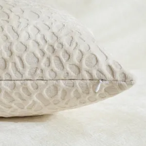 Detailed view of beige chenille throw pillow cover, textured jacquard pattern with zipper pull.