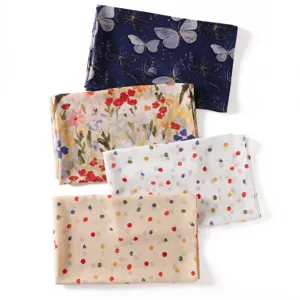 Écharpe longue imprimée en mousseline avec motifs de papillons, fleurs et pois colorés.