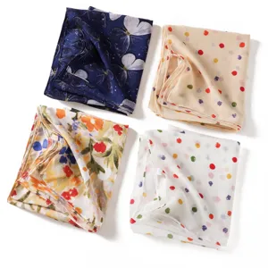 Détails de l'écharpe en mousseline tendance aux motifs élégants de papillons et de pois.