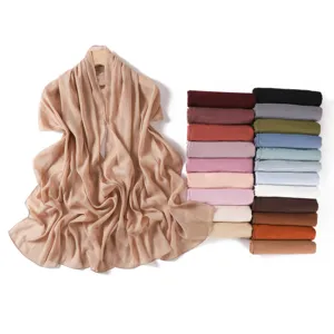 Detail view of shimmering pleated chiffon scarf in beige, showcasing fine texture and elegant drape.