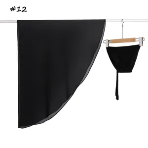 Gedetailleerd overzicht van zwarte chiffon sjaal en modal muts hangend aan witte roede.