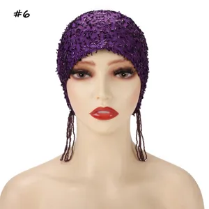 Close-up detail of the purple sequined mesh beaded cap with long hanging tassels.
