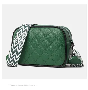 Green quilted genuine leather crossbody bag featuring a wide geometric pattern strap, detail view.