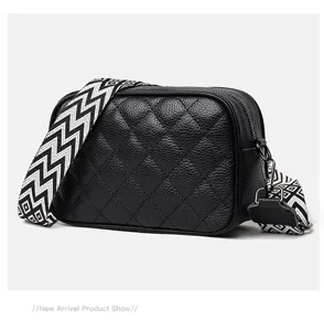 Genuine leather quilted crossbody bag with wide patterned strap, stylish black shoulder bag.