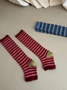 Classic striped stirrup socks and knee-high socks detail, cozy combed cotton texture for women.