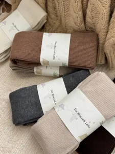 Cozy ribbed winter tights and leggings in warm neutral colors, soft stretch fabric detail view.