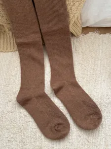 Cozy brown ribbed knit tights detail, winter warm wool blend texture close up view