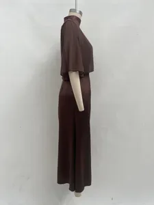 Détail de vue latérale d'une élégante robe en satin marron avec texture lisse et silhouette.