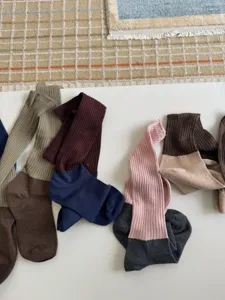 Détail de chaussettes empilées côtelées bicolores, bas rétro polyvalents d'automne pour femmes.
