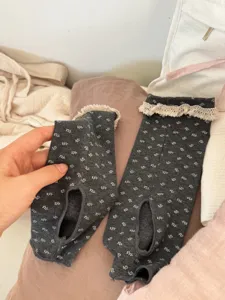 Detailed view of grey floral stirrup socks with delicate lace trim, cozy and sweet style.