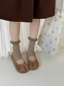 Detailed close-up of brown vintage floral crew socks with cute lace ruffles and soft fabric.