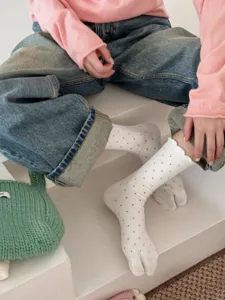 Comfortable white cotton polka dot split toe socks featuring cute ruffles and two toe design.