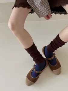 Gros plan détail de chaussettes slouch rétro côtelées pour femmes avec chaussures.