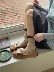 Cozy women's floral print socks with black lace trim paired with cute fuzzy moccasins.