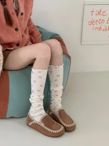 Détail de chaussettes hautes et douces à imprimé mignon d'ours pour un look adorable.