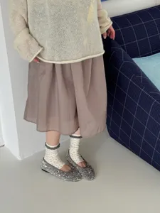 Detailed close-up view of sweet floral ruffled socks styled with sequin flats and knit top.