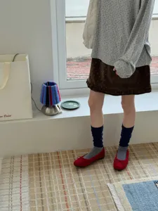 Chaussettes slouch côtelées bleu foncé confortables avec chaussures plates pour style rétro.
