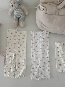 Détail en gros plan de jambières à motif d'ours doux avec un tissu en tricot et des pois.
