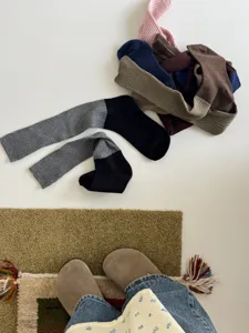 Gros-plan détail des chaussettes empilées côtelées color-block style rétro automne.