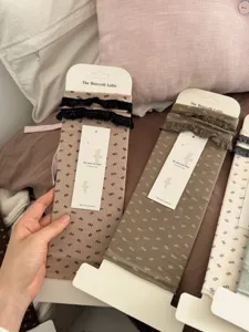 Detailed shot of cute floral stirrup socks with delicate lace trim on neat packaging cards.