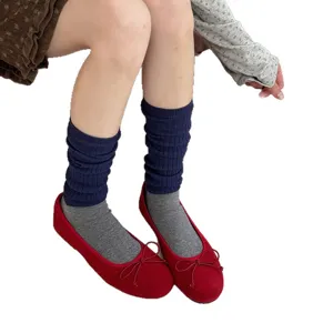 Chaussettes montantes côtelées pour femmes avec chaussettes grises et chaussures plates rouges.