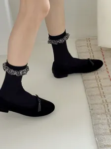 Chic black mid-calf socks featuring delicate ruffled lace trim, elegant and comfortable style.