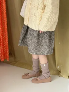 Detail shot of cozy wool knit leg warmers paired with cute shoes, ideal for autumn and winter.