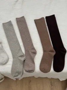 Detailed view of women's autumn and winter solid color wool calf socks in various neutral shades.
