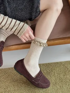 Stylish beige ribbed mid-calf socks featuring trendy leopard print ruffle cuffs for women.