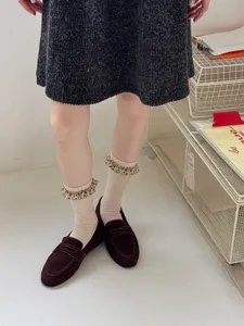 Detailed shot of Korean style women socks with floral lace ruffles, casual autumn mid tube socks.