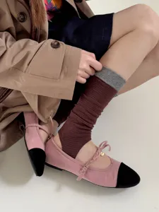 Detail shot of women's color-block stirrup socks with ribbed texture, cozy autumn look.