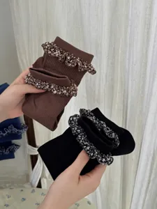Detailed shot of women ruffle mid-tube socks with floral lace trim and cozy ribbed texture.