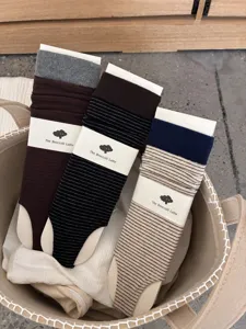 Detailed shot of three pairs of striped footless socks in a fabric basket, cozy style.