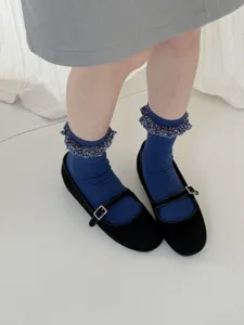 Detailed close-up view of elegant blue floral ruffle trim mid-tube socks with shoes.