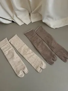 Comfortable mid-calf split-toe socks in solid colors, featuring a soft rolled edge design.