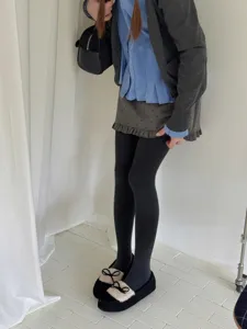 Detailed shot of dark grey ribbed thermal tights worn with cute bow shoes, stylish outfit view.