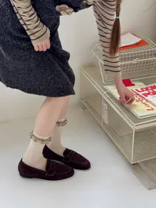 Detail shot of Korean style ruffled mid-calf socks paired with brown loafers, cozy daily wear.