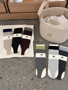 Detailed view of striped stirrup socks for women, trendy autumn winter stacked socks with color block.